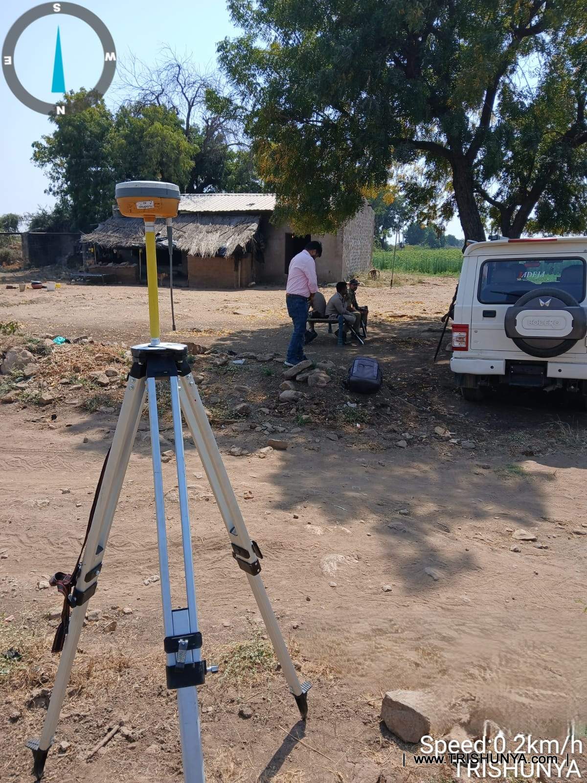DGPS base station setup with survey team and police escort planning survey route under tree shade in Gujarat