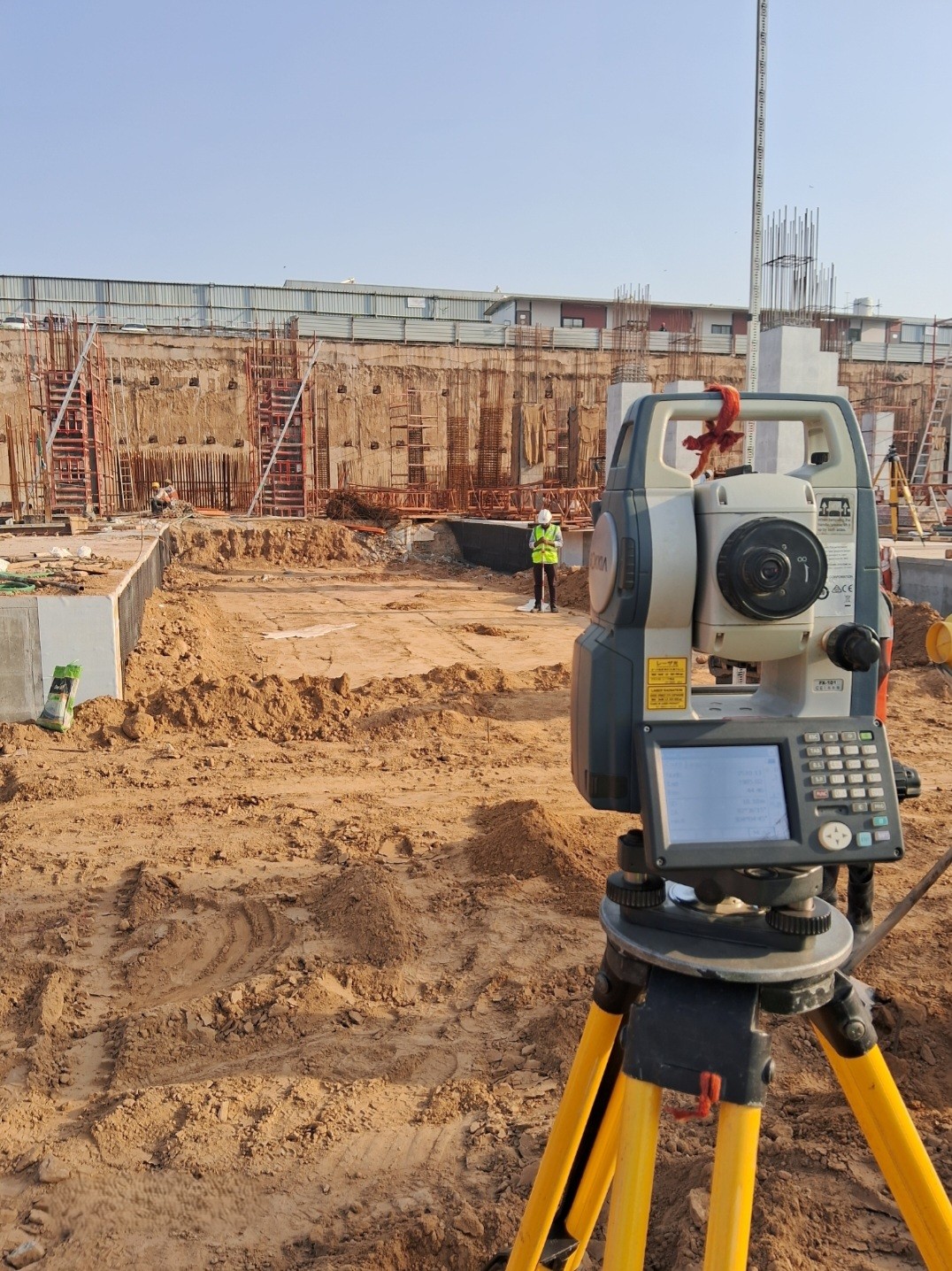 Total Station being used to mark foundation points on a large construction site