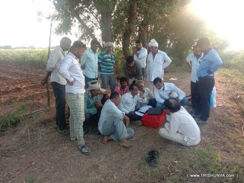 Farmers gathered around surveyor after total station land area survey completion