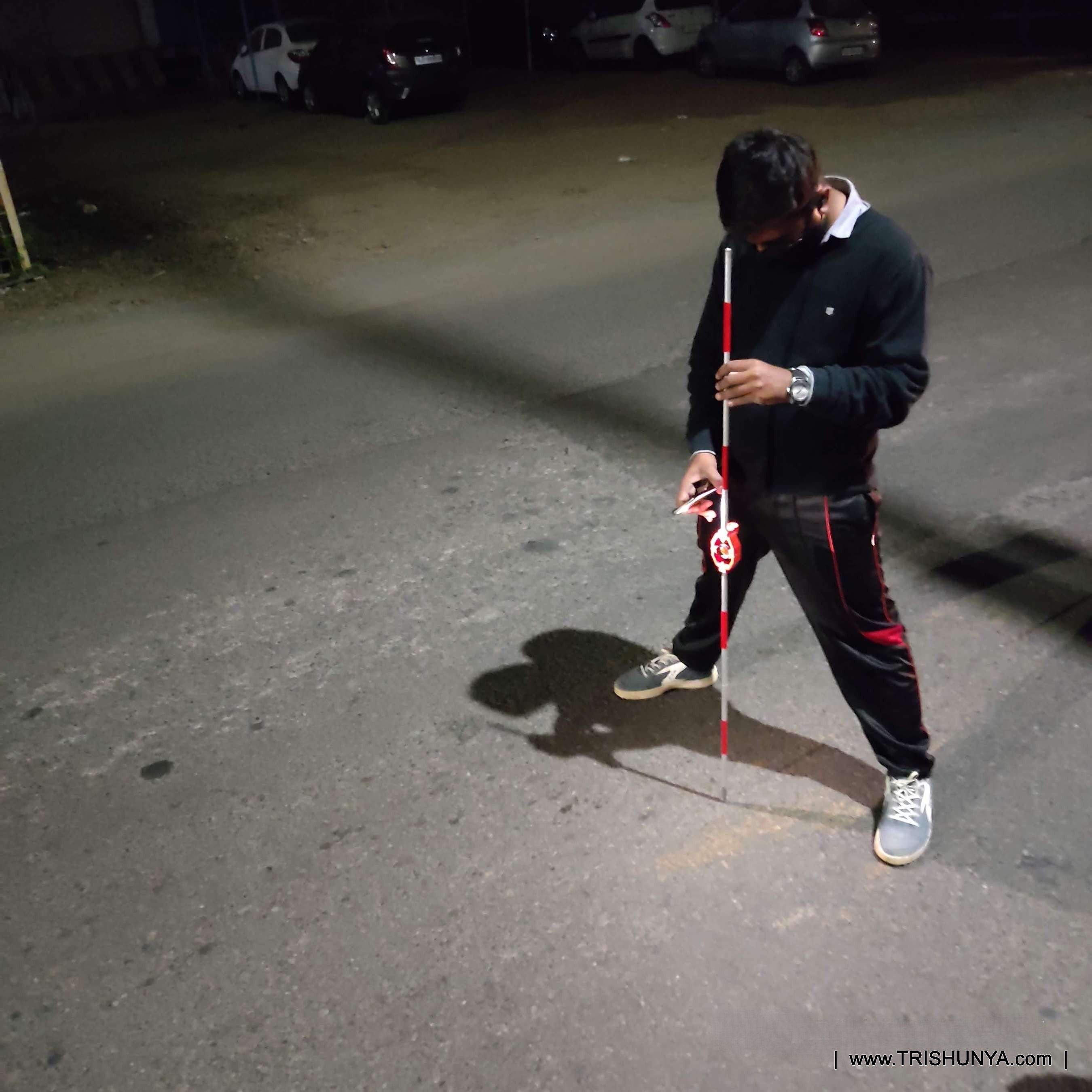Surveyor using mini prism at night with mobile torch light for bridge center line marking