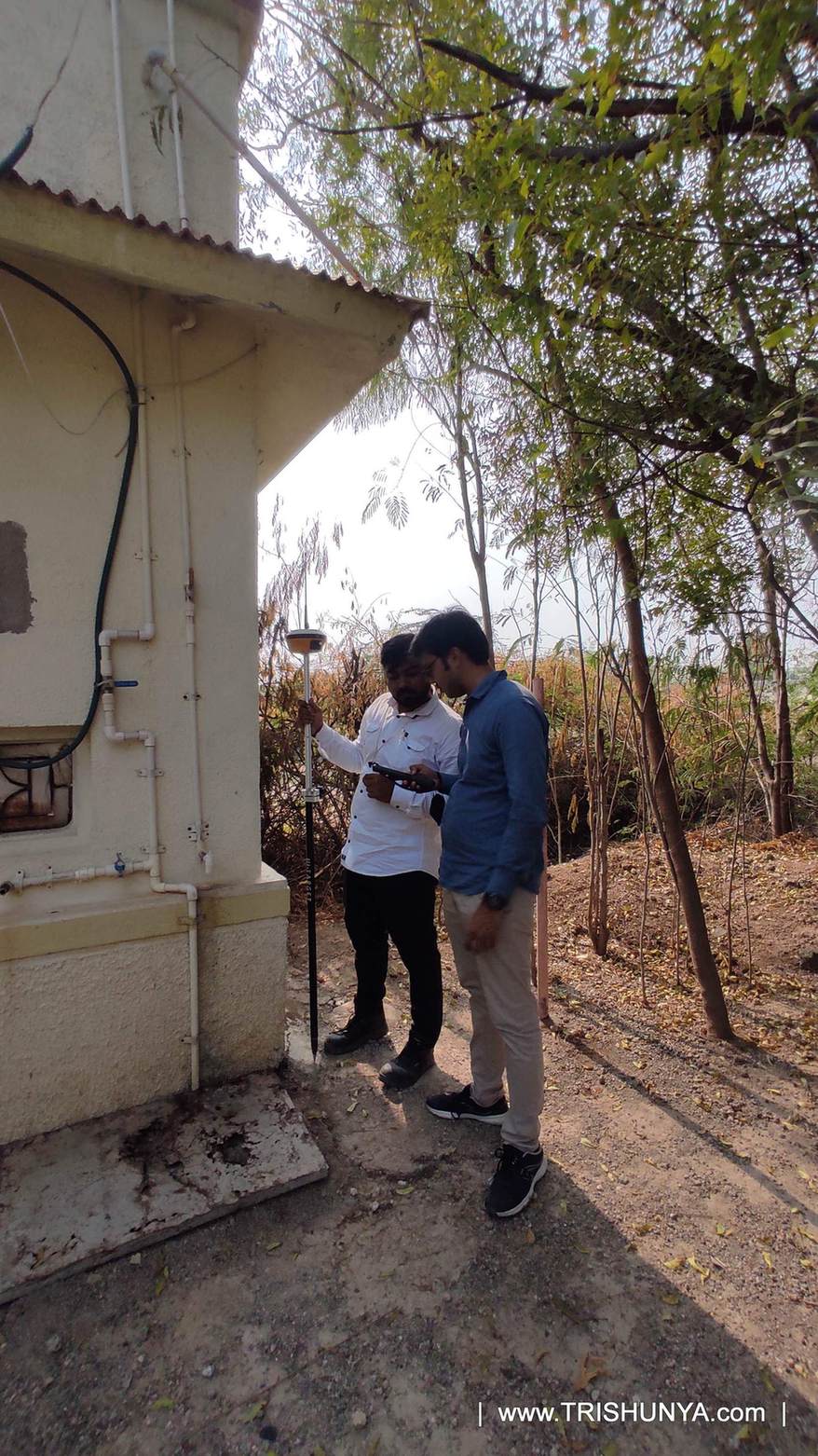 DGPS survey team capturing building corner points during topographic survey